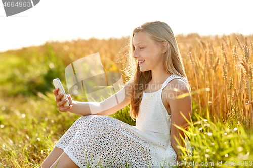 Image of happy young girl taking selfie by smartphone