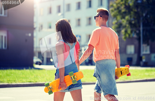 Image of teenage couple with skateboards on city crosswalk