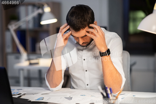 Image of businessman with papers working at night office