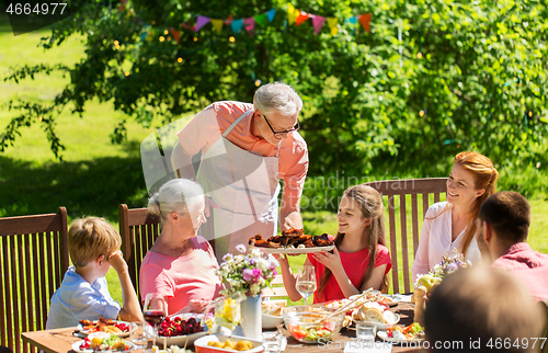 Image of happy family having dinner or summer garden party