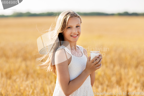 Image of girl with glass of milk on cereal field