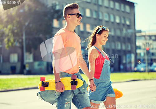 Image of teenage couple with skateboards on city street