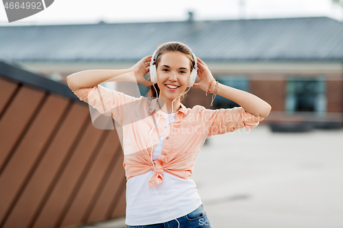 Image of happy teenage girl with headphones in city