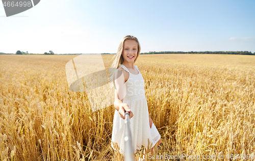 Image of happy girl taking selfie on cereal field