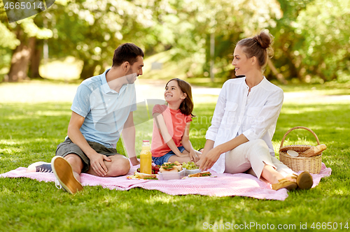 Image of happy family having picnic at summer park