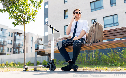 Image of businessman with scooter calling on smartphone