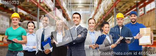 Image of group of business people and warehouse workers