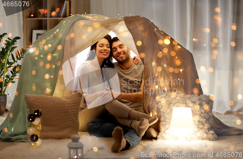 Image of happy couple in kids tent at home