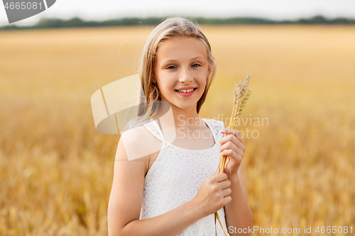 Image of girl with spikelet of wheat on cereal field