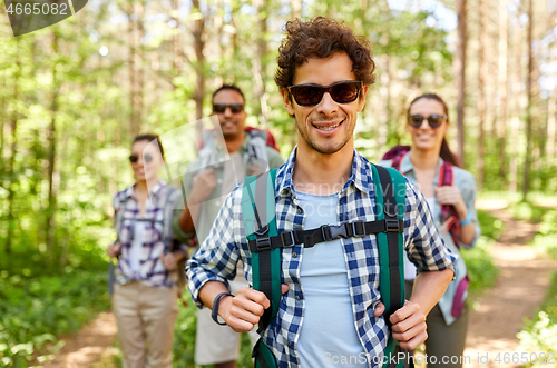 Image of friends with backpacks on hike in forest