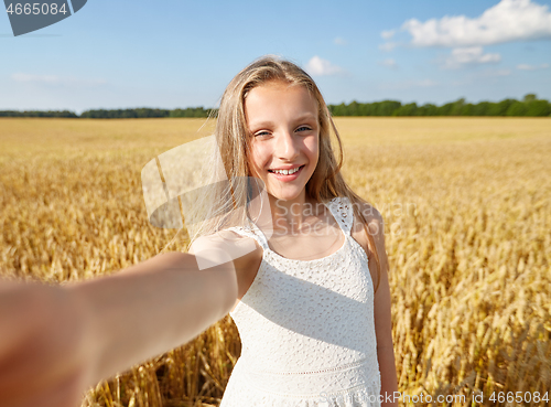 Image of happy girl taking selfie on cereal field