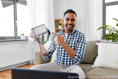 Image of male blogger with vr glasses videoblogging at home