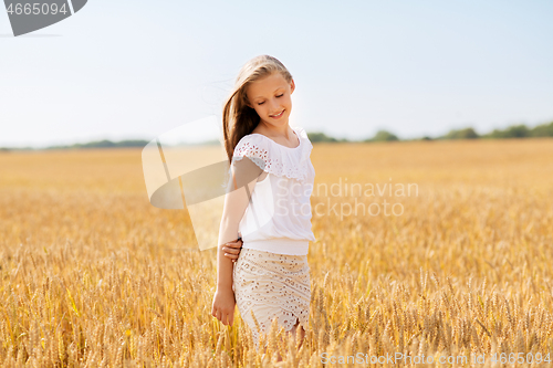 Image of smiling young girl on cereal field in summer