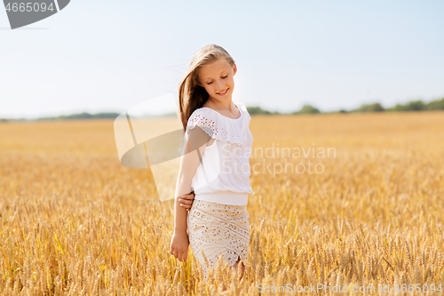 Image of smiling young girl on cereal field in summer