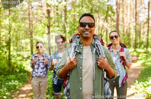 Image of friends with backpacks on hike in forest