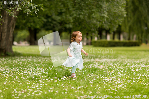 Image of happy little baby girl running at park in summer