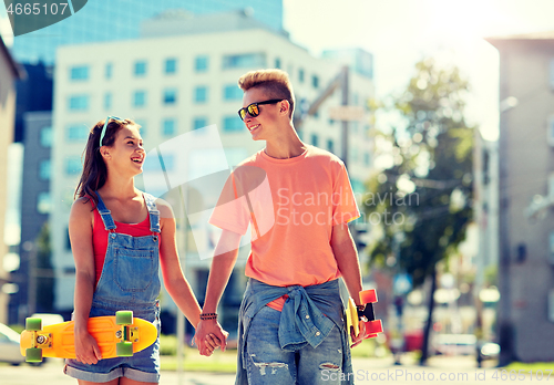 Image of teenage couple with skateboards on city street