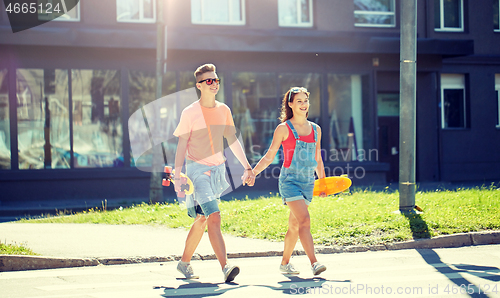 Image of teenage couple with skateboards on city street