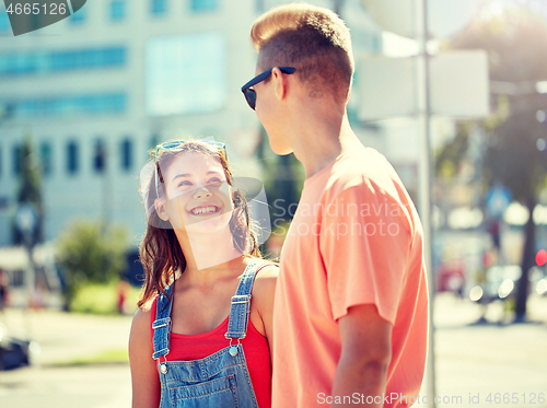 Image of happy teenage couple looking at each other in city