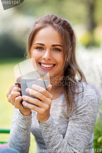 Image of woman drinking tea or coffee at summer garden