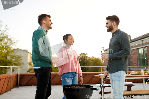 Image of happy friends having bbq party on rooftop