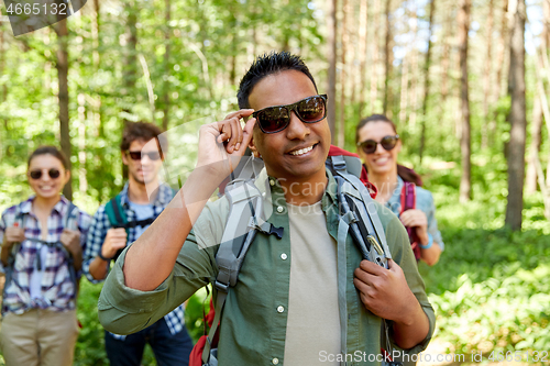 Image of friends with backpacks on hike in forest