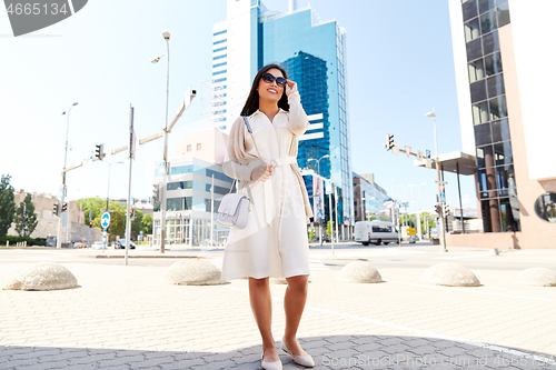 Image of happy smiling young woman on city street