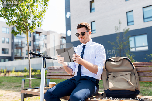 Image of businessman with tablet computer, bag and scooter