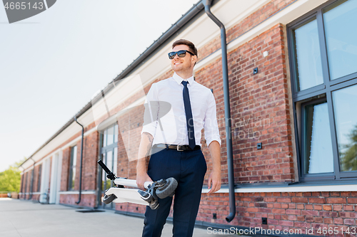 Image of businessman with folding scooter on rooftop