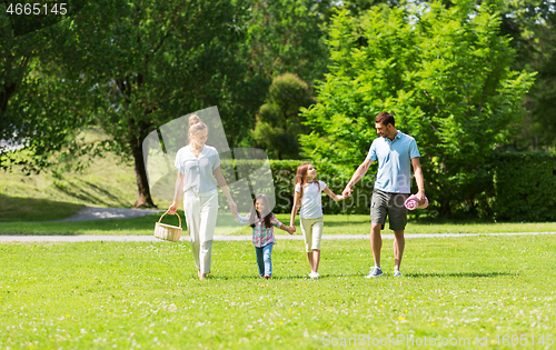 Image of family with picnic basket walking in summer park