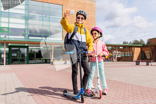 Image of happy school kids with scooters taking selfie