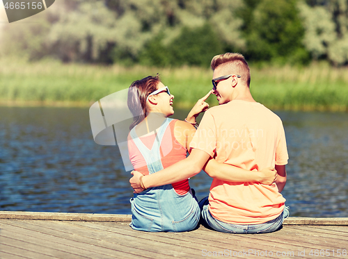 Image of happy teenage couple hugging on river summer berth