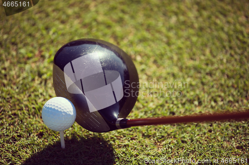 Image of top view of golf club and ball in grass