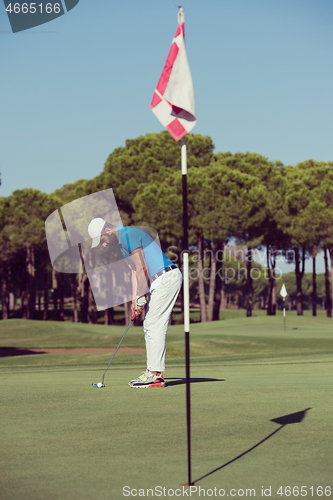 Image of golf player hitting shot at sunny day