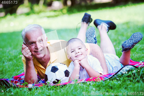 Image of grandfather and child have fun  in park