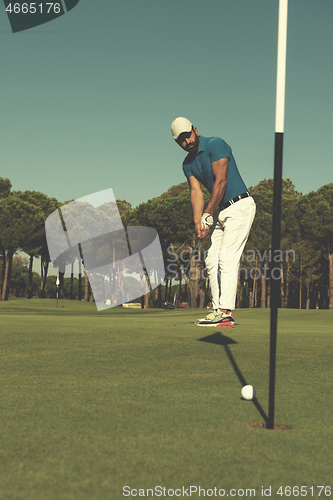 Image of golf player hitting shot at sunny day