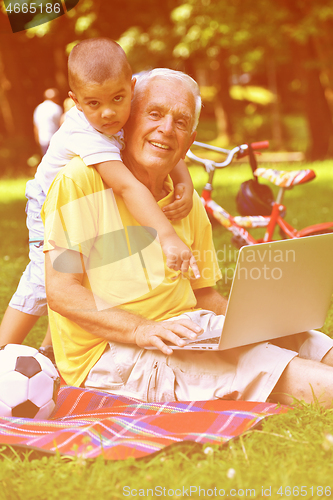 Image of grandfather and child using laptop