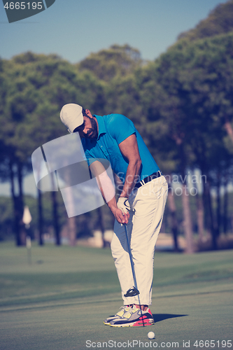 Image of golf player hitting shot at sunny day