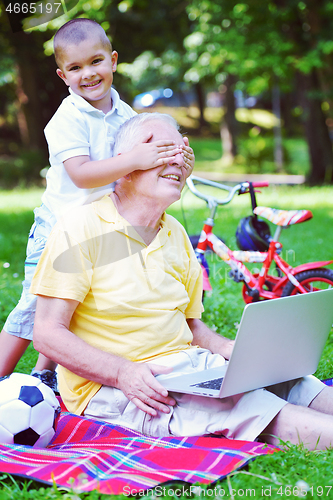 Image of grandfather and child using laptop