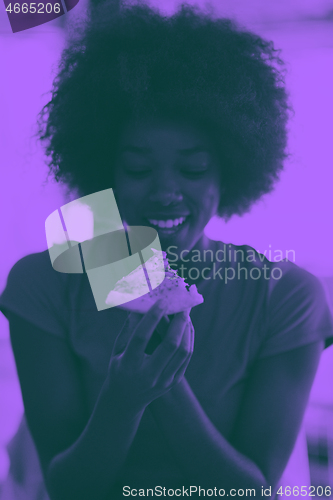 Image of woman with afro hairstyle eating tasty pizza slice