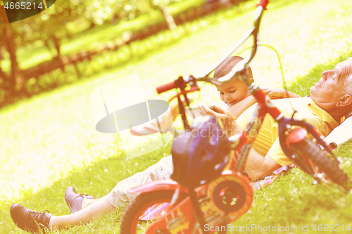 Image of grandfather and child in park using tablet