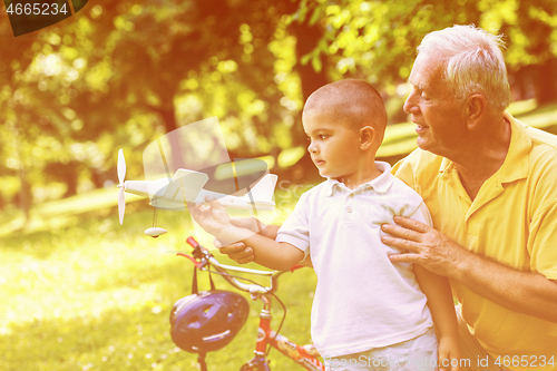 Image of grandfather and child have fun  in park