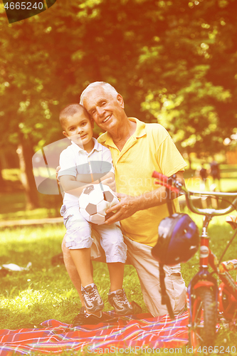 Image of grandfather and child have fun  in park