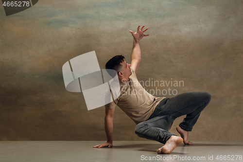 Image of The young man dancing on gray