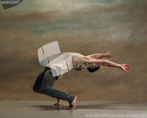 Image of The young man dancing on gray