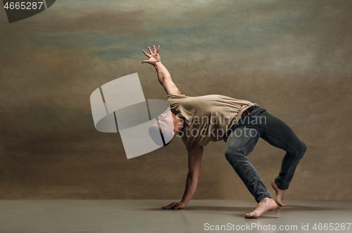 Image of The young man dancing on gray