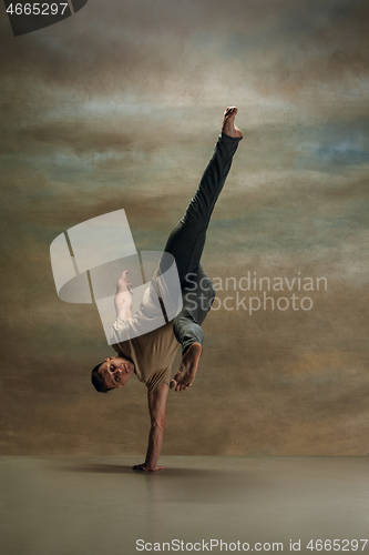 Image of The young man dancing on gray