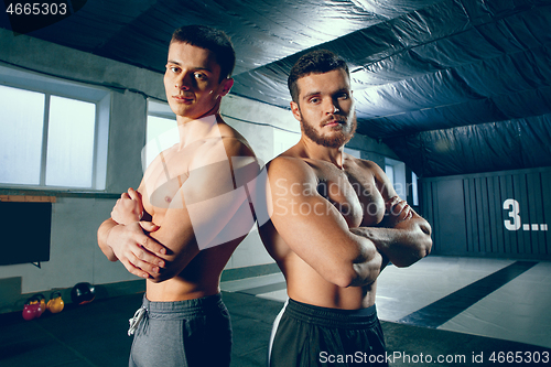 Image of Portrait of young people resting and looking at camera after training session in gym.