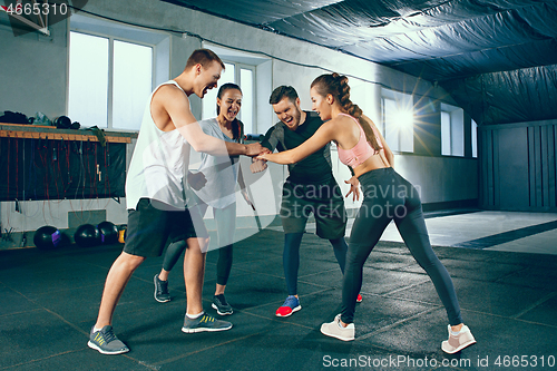 Image of Image of group of sporty muscular people are having rest after working out in gym.