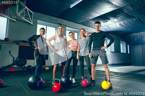 Image of Portrait of young people resting and looking at camera after training session in gym.